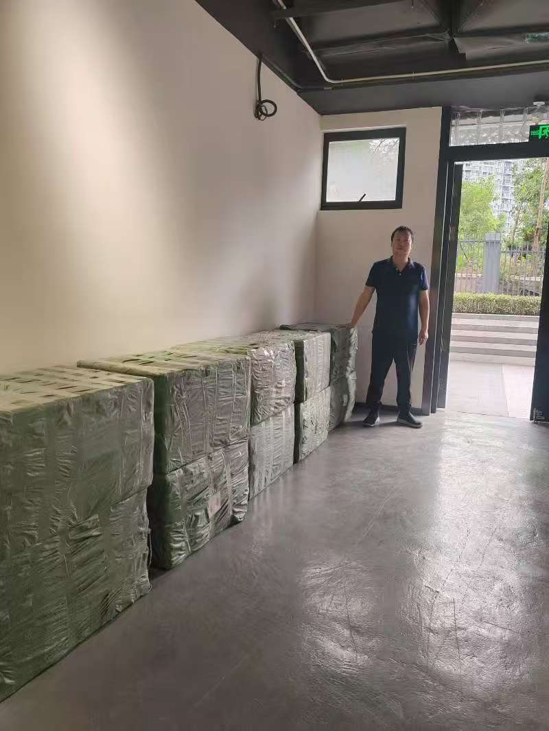 China sourcing agent standing with repacked goods in Shenzhen warehouse