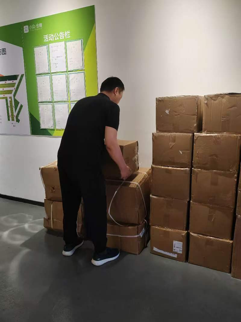 Zhiwei Yan organizing cartons to save shipping costs for a Middle Eastern client.